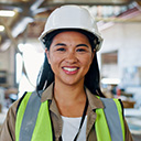 expertum - Eine Frau mit weißem Schutzhelm und gelber Warnweste steht in einer industriellen Arbeitsumgebung, im Hintergrund sind unscharfe Maschinen und Träger zu sehen. Das Bild vermittelt Professionalität und Engagement und verdeutlicht die Bedeutung von Fachkräften in der Industrie, bei der Projektarbeit und in der modernen Zusammenarbeit – ein Bezugspunkt sowohl für Unternehmen als auch für Bewerber im Bereich der Personalvermittlung.